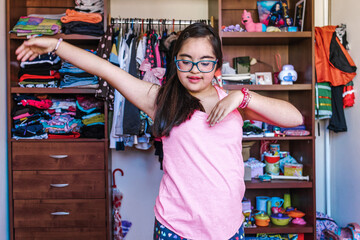 portrait of latin girl teenager with Down syndrome dancing in home in disability concept in Latin America	