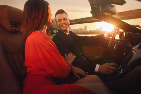 Beautiful couple in luxury convertible car outdoors