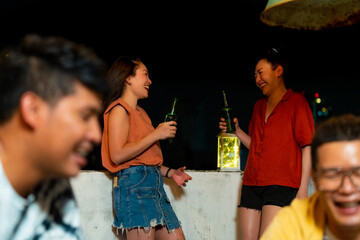 Group of Diversity Asian millennial people friends enjoy outdoor dinner party with eat korean food barbecue grill and alcoholic drink at rooftop for meeting reunion and holiday celebration together