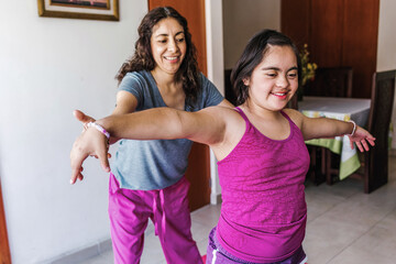 hispanic girl with Down syndrome doing yoga at home with her mother in Latin America disability...