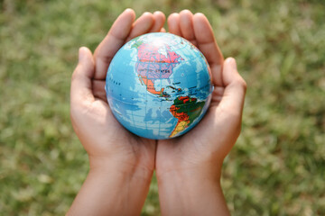 Save The Earth and Care Environment Concept, Close-up of Woman Hands is Holding Mockup Global Against on Tree Leave Background. Save Planet Earth for The Future Life and Environmental Sustainable