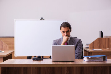 Young male business trainer in the office during pandemic