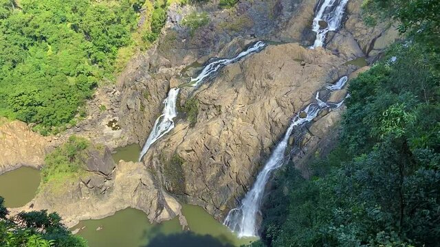 Smooth slow panning shot of the dramatic rocky Barron Falls in the middle of the dense tropical rain forest jungles of North Queensland