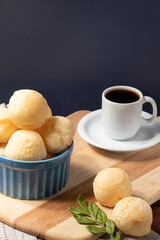 Cheese bread (pão de queijo) in a blue bowl and black coffee.