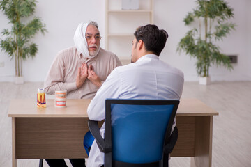 Old male patient visiting young male doctor dentist