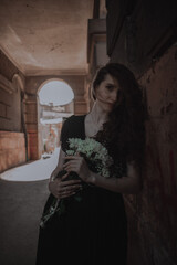 Curly girl in a black dress against the backdrop of the city