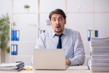 Obraz premium Young businessman employee unhappy with excessive work in the of
