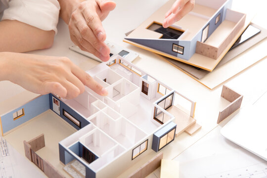 住宅模型を見ながら打ち合わせする施主と設計師