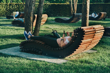 wooden sun beds on the lawn in the park. recreation area