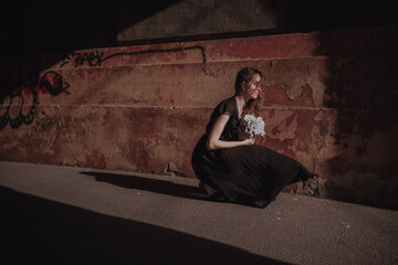 Curly girl in a black dress against the backdrop of the city