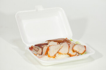 Barbecued red pork rice in a foam box on a white background. Fast and Street food in Thailand.