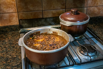 Cooking typical Brazilian dish called Feijoada. Made with black beans, pork and sausage.