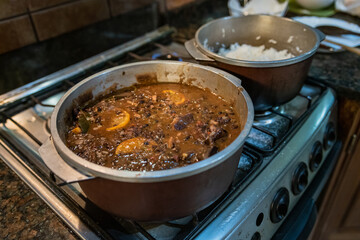Cooking typical Brazilian dish called Feijoada. Made with black beans, pork and sausage.