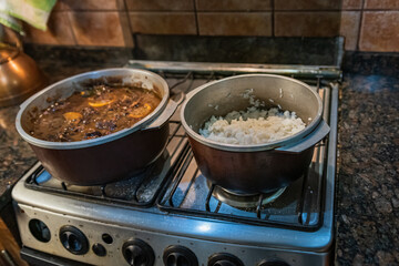 Cooking typical Brazilian dish called Feijoada. Made with black beans, pork and sausage.