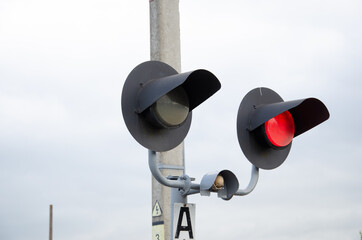 Square Grade crossing signal with red light gate and crossbuck at railroad crossing.