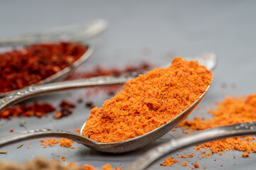 Variety of herbs and spices on slate background.