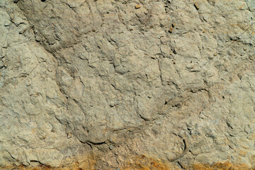 Close-up of uneven surface of a gray rock. Material for construction