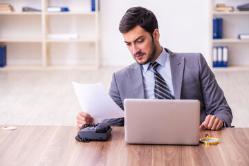 Young handsome businessman employee working in the office