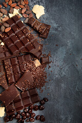 Cacao beans and chocolate on gray background.