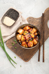 Traditional homemade fried tofu with sesame on light gray background.