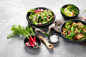 Freshly made salads on light gray background. Seasonal food concept.
