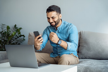 Indian business man screaming cheering reading great news on smartphone