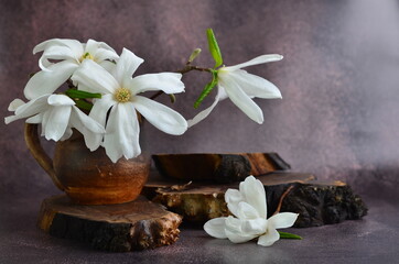 White magnolias lie on a wooden stand.