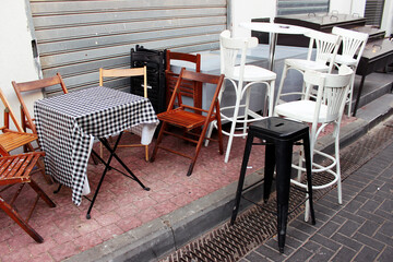 A closed cafe before Shabbat near a cafe in the Carmel market area in Tel Aviv, Israel. Tables and chairs before Shabbat.