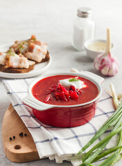 Delicious fresh red borscht, dark bread with lard and salt on kitchen table. 