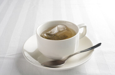 a cup of hot green tea leaf in bag on white background halal beverage menu