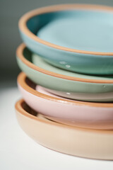 A large stack of ceramic cups in pastel colors.