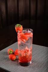 iced strawberry fruit cooler mocktail / kombucha in glass on bar counter dark night background cold halal drink menu