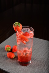 iced strawberry fruit cooler mocktail / kombucha in glass on bar counter dark night background cold halal drink menu