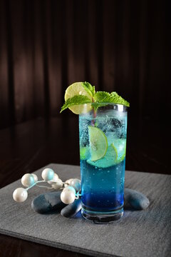 Iced Blue Island Cooler Soda Mocktail With Lime And Mint Leaf Kombucha In Glass On Bar Counter Dark Night Background Cold Halal Drink Menu