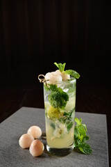 iced lychee longan mint fizz mocktail with mint leaf kombucha in glass on bar counter dark night background cold halal drink menu