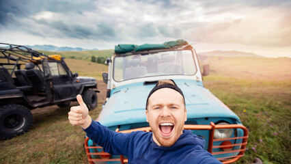 Happy man traveler make selfie photo on background of extreme ATV. Concept car travel safari park tour in Africa summer