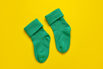 Baby socks on color background