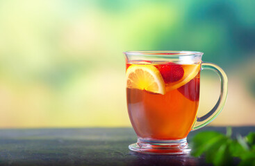 Fresh tea with lemon and strawberries in a large glass cup