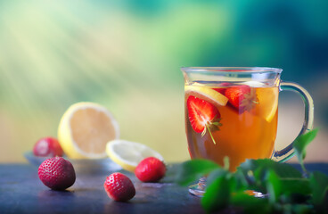 Fresh tea with lemon and strawberries in a large glass cup