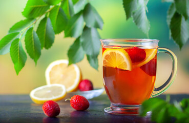 Fresh tea with lemon and strawberries in a large glass cup