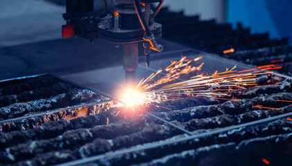 Closeup macro CNC plasma cutting metal iron material with sparks, industry background