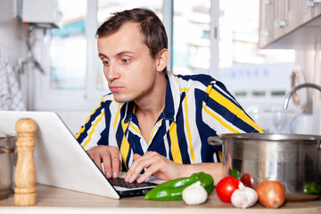Portrait of a man searching for a recipe for dishes on the Internet