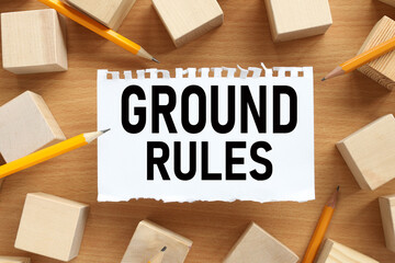 Ground Rule. text on white torn paper. near the wooden cubes