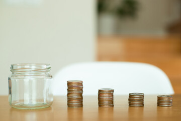 Money saving and finance concept. Empty jar and money on a wooden table. She saving the money for the future, education, investment and retirement.