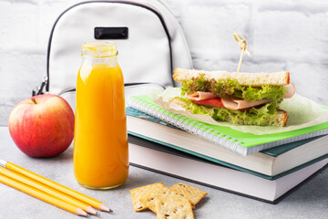 Snack for school with sandwich, fresh Apple and orange juice. Colorful school supplies,