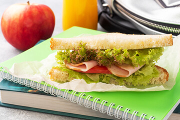 Snack for school with sandwich, fresh Apple and orange juice. Colorful school supplies,