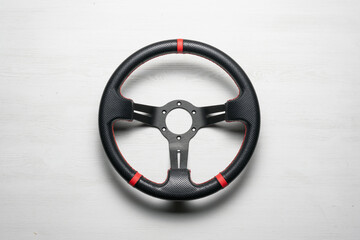 A sport car steering wheel on the white flat lay background.