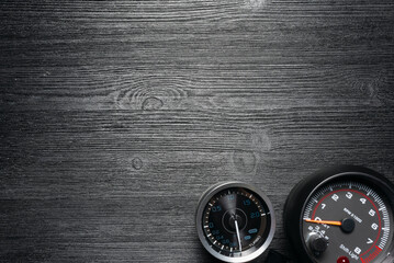 Car tachometer and turbine pressure gauge on the black flat lay background with copy space.