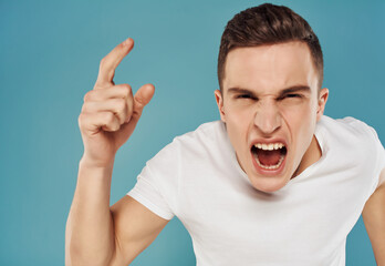 emotional man in white t-shirt anger blue background