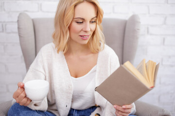 young beautiful woman with cup of coffee and book